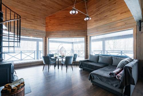 ein Wohnzimmer mit einem Sofa und einem Tisch mit Stühlen in der Unterkunft Holiday House "Brūklenes" in Talsi