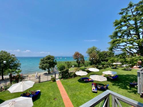 a view of a park with umbrellas and the ocean at Hotel Campagnola in Bardolino