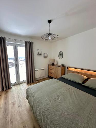 a bedroom with a large bed and a large window at Apartmán Bezinka in Lipno nad Vltavou