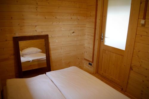 a bedroom with a mirror and two beds in it at Camping Szczecinek Domy Wypoczynkowe in Szczecinek
