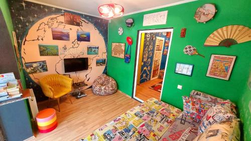 Hostel Amazing Ionika CenterCity في كيشيناو: غرفة معيشة مع أريكة وجدار أخضر