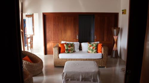 a living room with a couch and orange pillows at Casa Terravista Trancoso in Trancoso