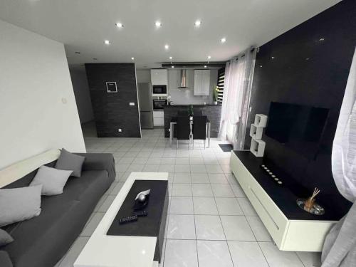 ein Wohnzimmer mit Sofa und Tisch in der Unterkunft Très bel appartement entre Paris et Disneyland in Lognes