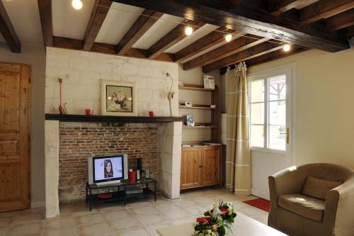 a living room with a brick fireplace and a couch at Le petit pre des marguerites in Rosnay-lʼHôpital