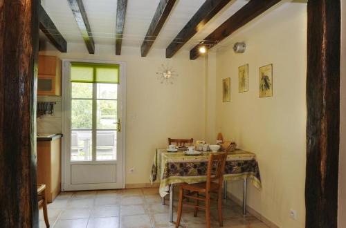 eine Küche mit einem Tisch mit Stühlen und einem Fenster in der Unterkunft Le petit pre des marguerites in Rosnay-lʼHôpital