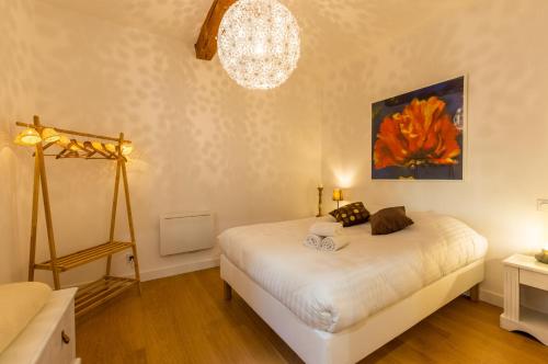 um quarto com uma cama e um lustre em Petit coeur de ville - Premiere conciergerie em Montpellier