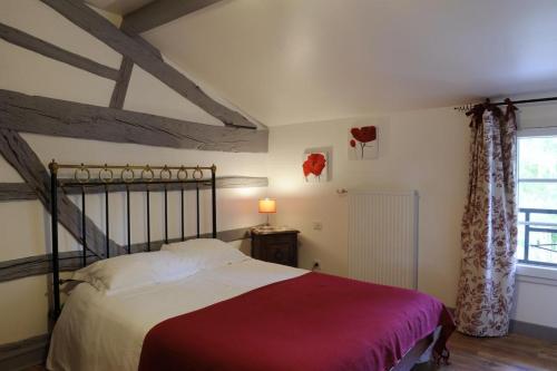 ein Schlafzimmer mit einem Bett und einem Fenster in der Unterkunft Le pre des marguerites in Rosnay-lʼHôpital