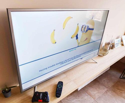 a large screen television sitting on a table with bananas on it at AG Casa Rural Carballo, jardín y playa a 14km in Artes