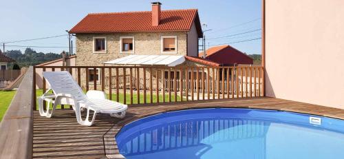una terraza con una silla y una piscina en AG Casa Rural Carballo jardín y playa a 14km, en Artes