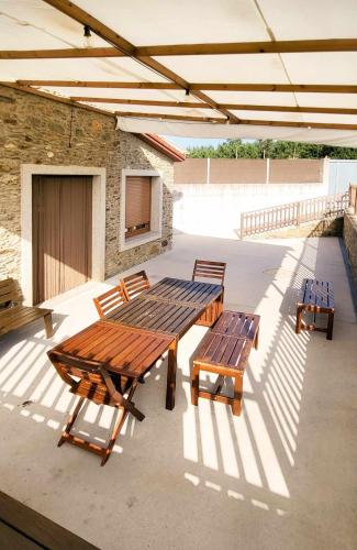 a picnic table and benches on a patio at AG Casa Rural Carballo, jardín y playa a 14km in Artes