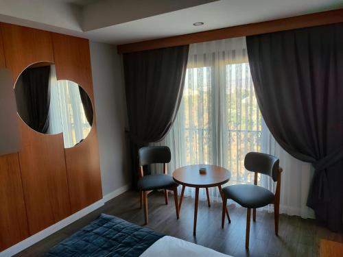 a hotel room with a bed and a table and chairs at May park HOTEL in Izmir
