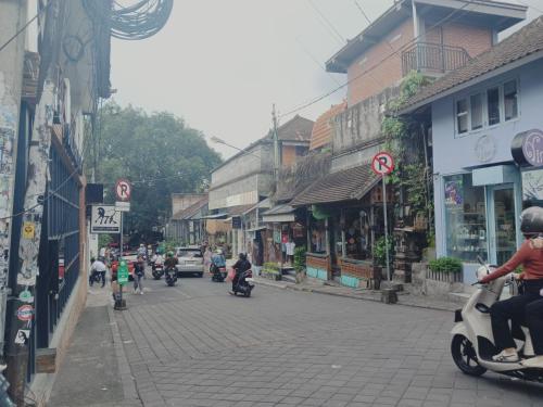 a group of people riding motorcycles down a street at Sudana Homestay in Ubud City in Ubud