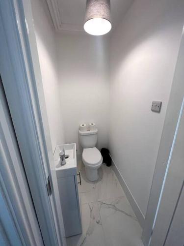 a white bathroom with a toilet and a sink at No. 51 - Modern 4 bed in Liverpool