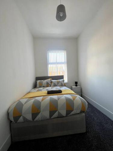 a bedroom with a bed in a white room at No. 51 - Modern 4 bed in Liverpool