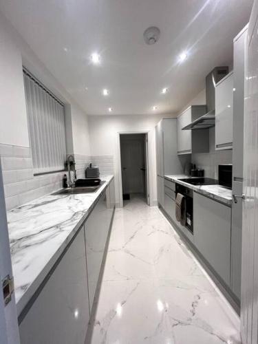 a large kitchen with white marble floors and counters at No. 51 - Modern 4 bed in Liverpool