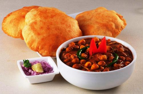 a bowl of chili and a plate of bread at FabExpress Crystal Stay in Bhubaneshwar