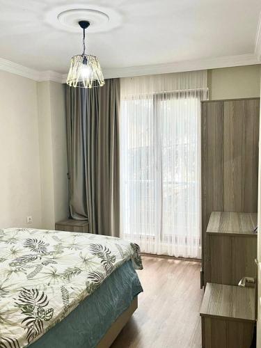 a bedroom with a bed and a chandelier at Halic Apart Hotel in Yalova