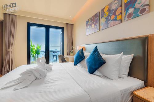 a bedroom with a large white bed with blue pillows at Son&Henry Zenity District 1 in Ho Chi Minh City