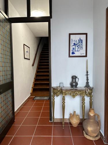 a hallway with a table and stairs in a house at Casa da Avó Ilda in Miranda do Douro
