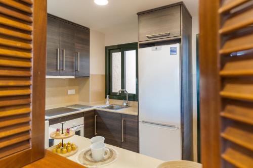 Fuente-Álamo de Murcia的住宿－App Paraïso - Golf Resort Hacienda，厨房配有白色冰箱和木制橱柜。