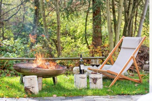 a fire pit and a chair and a bottle of wine at Apartment Bad Kleinkirchheim - 24 Chalet neben Therme und Wandergebiet in Bad Kleinkirchheim