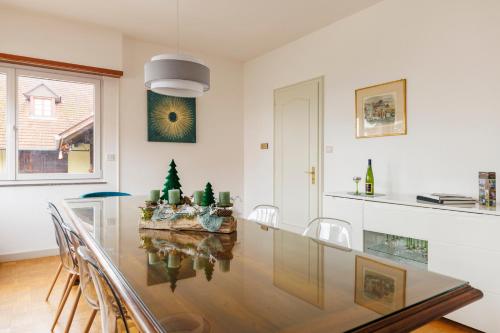 une salle à manger avec une table et des chaises en verre dans l'établissement Maison de caractère à Chatenois, à Châtenois