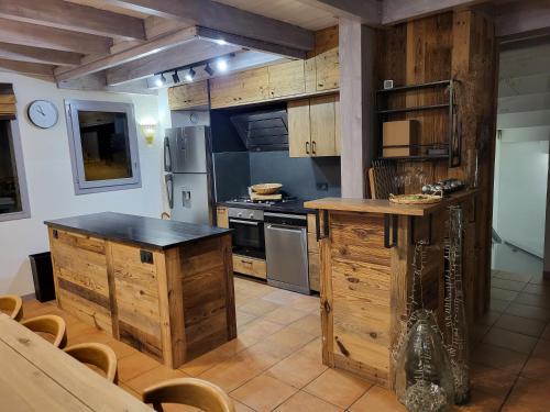 cocina con armarios de madera y horno con fogones en Chalet Courchevel La Tania - 14 personnes - 7 chambres 7 salles de bains - 40 m des pistes, en Courchevel