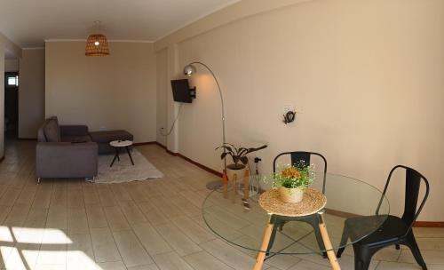 een woonkamer met een glazen tafel en stoelen bij Dpto. zona sur - Ubicación ideal in Santa Fe