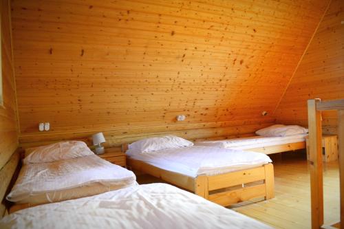 a room with two beds in a wooden cabin at Camping Szczecinek Domy Wypoczynkowe in Szczecinek