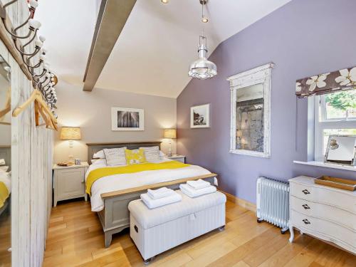 a bedroom with a bed and a purple wall at 2 Bed in Nidderdale G0156 in Hampsthwaite