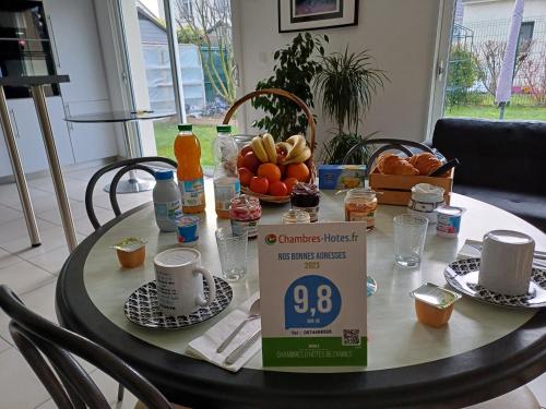 ランスにあるEtape au Calme à 4Km du Center de Reimsのオレンジジュースとフルーツの箱入りテーブル