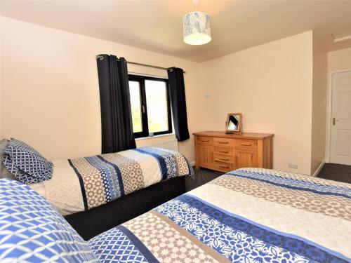 a bedroom with two beds and a window at 5 bed in Brynteg 75907 in Llanwenog