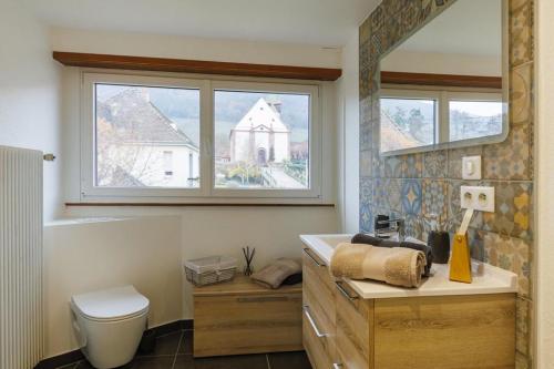 a bathroom with a sink and a toilet and a window at Maison de caractère à Chatenois in Châtenois