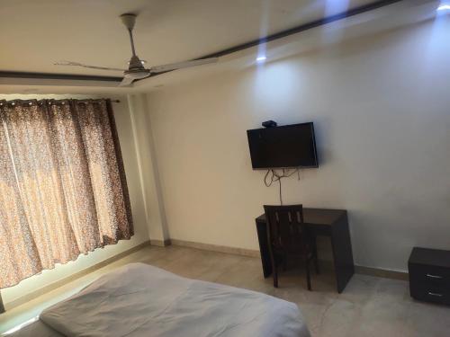 a bedroom with a bed and a flat screen tv at A J RESIDENCE in New Delhi