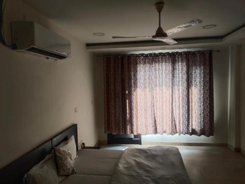 a bedroom with a bed and a large window at A J RESIDENCE in New Delhi