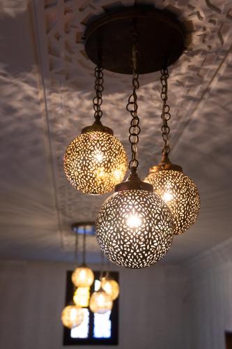 a group of lights hanging from a ceiling at Playa Del Sol Surf House in Tamraght Ouzdar