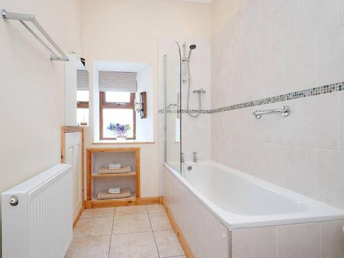 a white bathroom with a tub and a shower at 3 Bed in Corriecravie CA099 in Sliddery