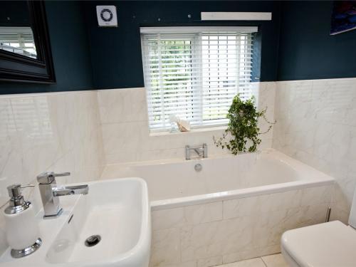 a bathroom with a tub and a sink and a toilet at 2 Bed in Hutton Magna G0116 in Hutton Magna