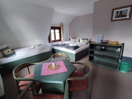 a room with two beds and a table and chairs at Auersberg Haus in Eibenstock