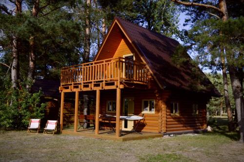 a log cabin with a balcony and a deck at Camping Szczecinek Domy Wypoczynkowe in Szczecinek