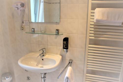 ein Bad mit einem Waschbecken und einem Spiegel in der Unterkunft Apartment Hotel in Henstedt-Ulzburg