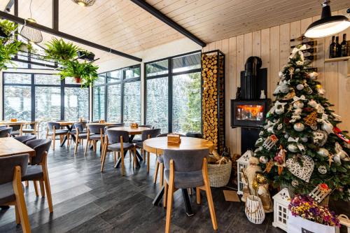 uma árvore de Natal num restaurante com mesas e cadeiras em Шишка em Bukovel