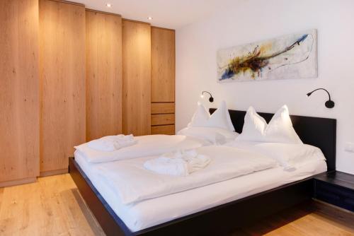 - une chambre avec un grand lit et des draps blancs dans l'établissement Apartment UB Two, à Eggen