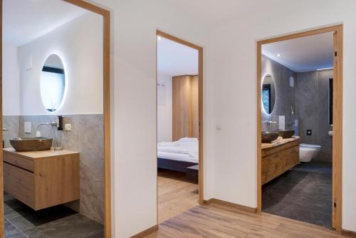 La salle de bains est pourvue de 2 lavabos et d'un grand miroir. dans l'établissement Apartment UB Two, à Eggen