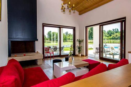 a living room with a red couch and a fireplace at Villa Dora in Central Istria kids friendly with private pool and playground for 10 persons in Svetvinčenat