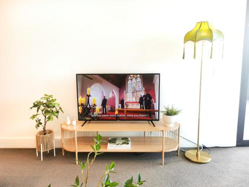 a living room with a flat screen tv on a table at French Country Style in Olympic Park in Sydney