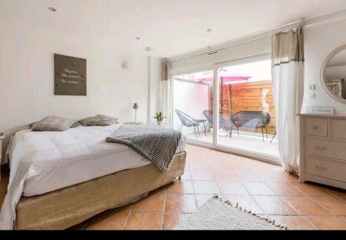 1 dormitorio con cama grande y ventana grande en Appart cosy avec terrasse, en Mons-en-Baroeul