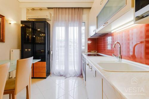 een keuken met een wastafel en een aanrecht met een raam bij Lavender 2bdrm Apartment, Vesta Philoxenia in Thessaloniki