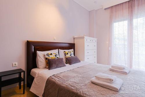 een slaapkamer met een groot bed en handdoeken bij Lavender 2bdrm Apartment, Vesta Philoxenia in Thessaloniki