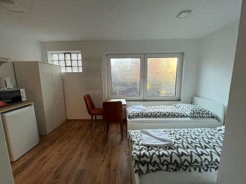 um quarto com duas camas e uma mesa e duas janelas em City Flats Dortmund em Dortmund